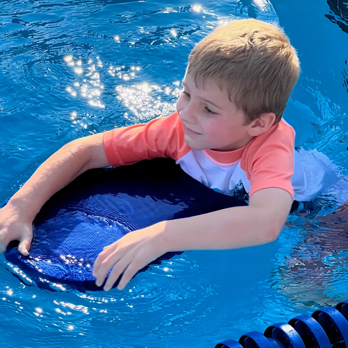 A young swimmer with a kickboard